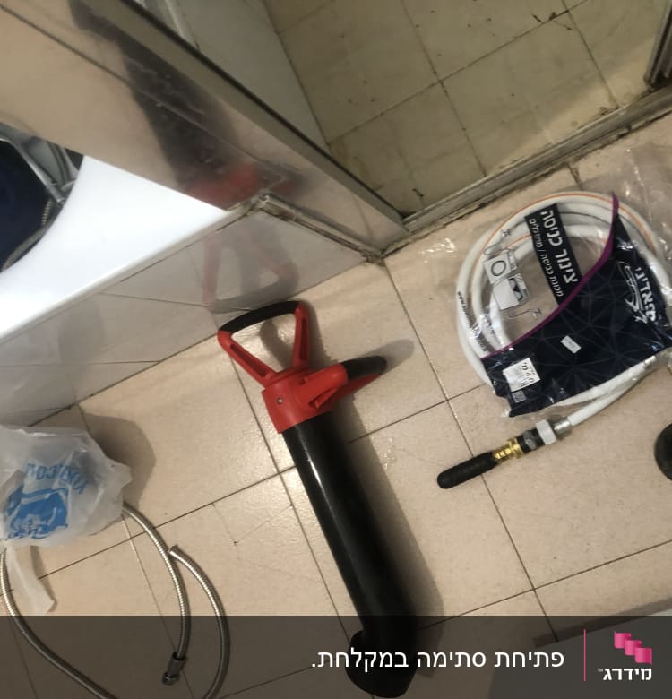 כלי עבודה של אינסטלטור על רצפה, כולל צינור ואביזרים